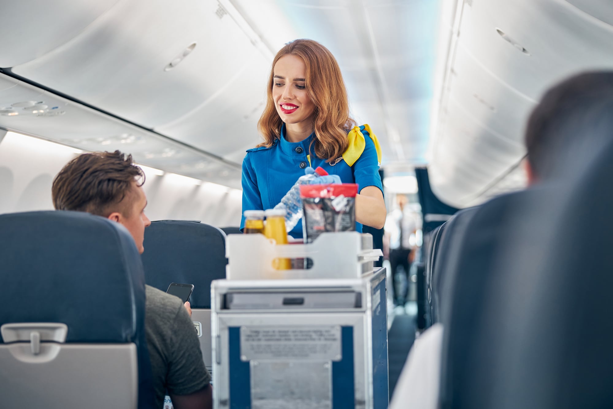 Flight attendant serving food and drinks to passengers on board